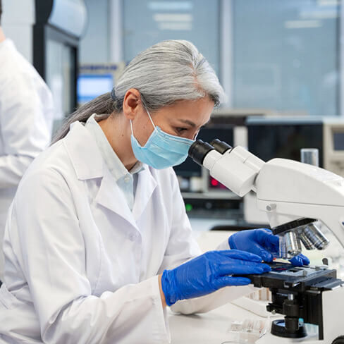 Attract woman looking through microscope